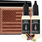 Two bottles of Airpurelle Santal Luxe fragrance diffuser oil with a wooden block featuring an American flag design.